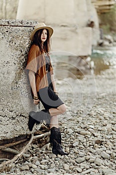 Beautiful stylish hipster woman in hat, fringe poncho and boots.