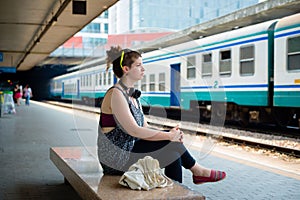 Beautiful stylish modern young woman waiting train