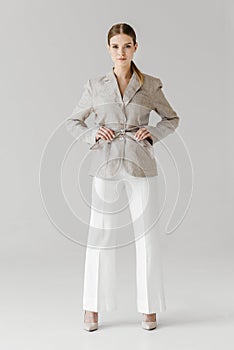 beautiful stylish woman adjusting belt of linen jacket