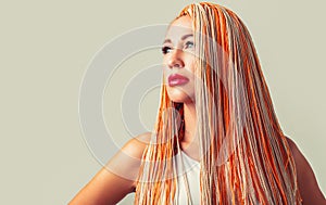 Beautiful stylish woman with colorful kanekalon braided in her hair. Pretty woman colorful orange hair braids