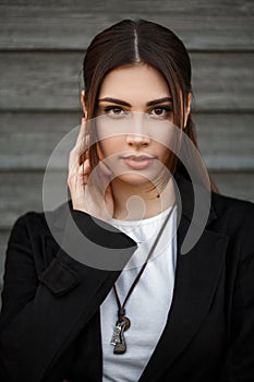 Beautiful stylish woman model in a black coat on the street.