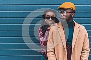 beautiful stylish young african american couple in jacket and overcoat posing together