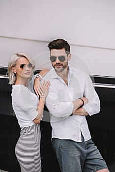 beautiful stylish young couple in sunglasses smiling at camera