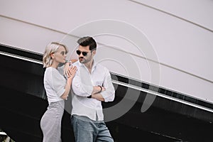 beautiful stylish young couple in sunglasses standing together
