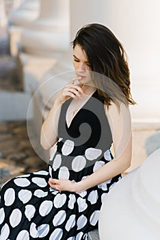 Beautiful stylish young pregnant woman holding her hand on her stomach