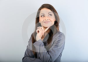 Beautiful success business woman in suit with finger under the face thinking and looking up on blue background. Closeup