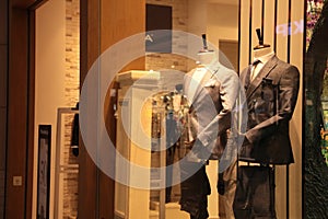 Beautiful suits on mannequins in showcases of fashion store