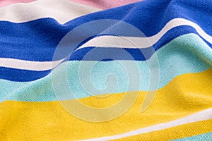 Beautiful summer background made of striped crumped fabric of delicate colors blue, yellow, pink photo