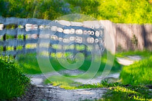 Countryside bokeh background in summer, wooden fence