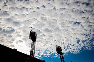 Beautiful summer blue sky and cloud and silhouetted stadium lights