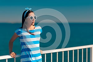 Beautiful summer fashion girl in navy striped shirt and sunglasses