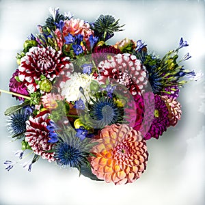 Dahlia flower bouquet with thistles and African lilies in vibrant colors, summer flowers in arrangement. Top view. photo