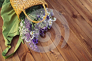 Beautiful summer flowers in a basket on a wooden patio