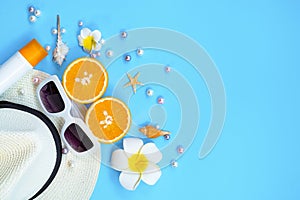 Beautiful summer holiday, Beach accessories, sunglasses, hat, orange, sunblock and shells on blue backgrounds