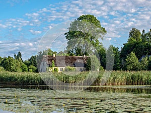 Beautiful summer landscape with calm lake, meadows,