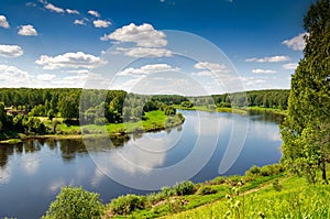 Beautiful summer landscape of meadows near the river and forest. The upper reaches of the Volga River in the Tver region of Russia