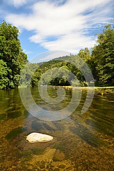 Beautiful summer landscape with river, forest, sun and blue skies. Natural background.