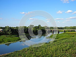 Beautiful summer landscape with a view of an old vintage bridge over a small river