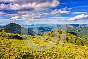 Beautiful summer mountain ridge, bright daytime landscape with green mountains and blue cloudy sky