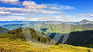 Beautiful summer mountain ridge, bright daytime landscape with green mountains and blue cloudy sky