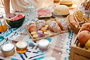 Beautiful summer picnic on the beach. Organic fresh fruit, croissants, colourful macarons or macaroons, watermelon, cold