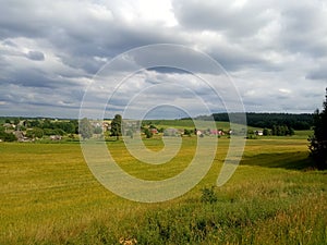 Beautiful summer rural landscape, field, hills, village