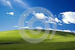 A beautiful summer or spring landscape with green grass on the hills and green fields. The blue sky is filled with white