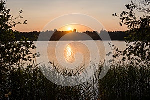 Beautiful summer sunset at the lake with blue sky, red and orange clouds