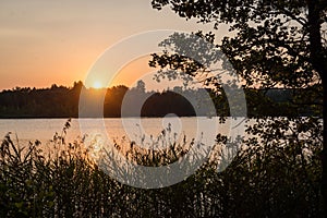 Beautiful summer sunset at the lake with blue sky, red and orange clouds