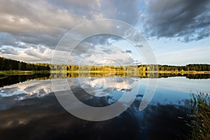 Beautiful summer sunset at the lake with blue sky, red and orange clouds