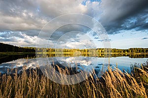 Beautiful summer sunset at the lake with blue sky, red and orange clouds