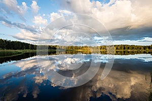 Beautiful summer sunset at the lake with blue sky, red and orange clouds