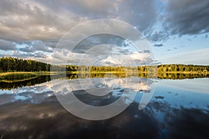 Beautiful summer sunset at the lake with blue sky, red and orange clouds