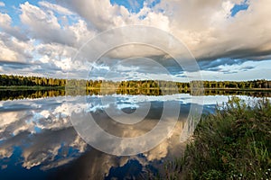 Beautiful summer sunset at the lake with blue sky, red and orange clouds