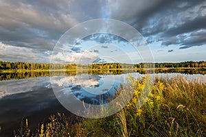 Beautiful summer sunset at the lake with blue sky, red and orange clouds