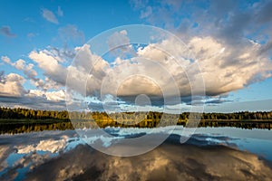 Beautiful summer sunset at the lake with blue sky, red and orange clouds