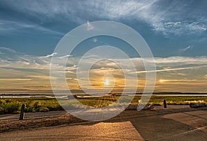 Beautiful summer sunset over a coastline with parhelia, sun dogs on each side