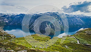 Beautiful summer vibrant view on famous Norwegian tourist place - trolltunga, the trolls tongue with a lake and mountains, Norway,