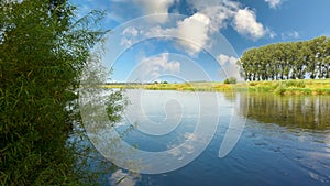 Beautiful summer view of landscape river with trees, blue sky and white clouds