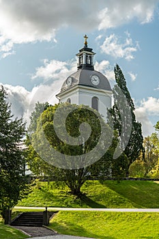 White church tower surrounded by lush green trees photo