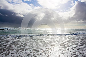 Beautiful sun, sea, dark skies, ocean waves, white water photo