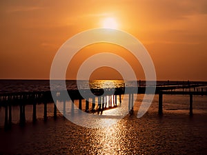 Beautiful sun Wooded bridge pole in the port between sunrise against orange sky calm peaceful moment relax holiday concept idea