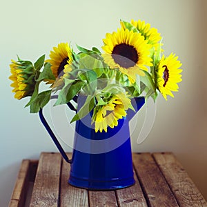 Beautiful sunflower bouquet in enamel jug photo