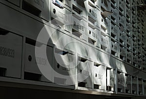 Beautiful sunlight shine on rows of white wooden mailboxes with keyholes for resident in condominium