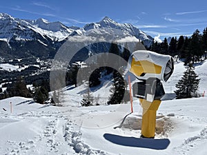 Beautiful sunlight and snow-capped alpine peaks above the Swiss tourist sports-recreational winter resorts