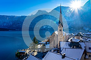 Beautiful sunny cityscape of the special city Hallstatt in Austria Salzkammergut snowy winter mountains and lake and church