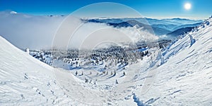 Beautiful sunny winter landscape in thÑƒ mountains. Mountain and fir trees covered with snow and clouds