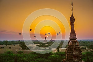A beautiful sunrise with balloons floating in the air in Bagan is a city of thousands of Buddhist pagodas.