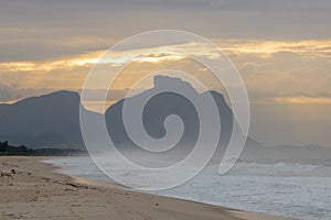 Beautiful sunrise on the beach of Barra da Tijuca with the stone of GÃ¡vea in the background