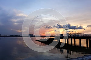 A beautiful sunrise with cloudy sky on the beach.